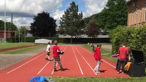 Kinder spielen auf dem Sandplatz der Ganztagesschule