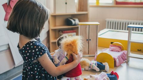 Kind spielt mit Puppen